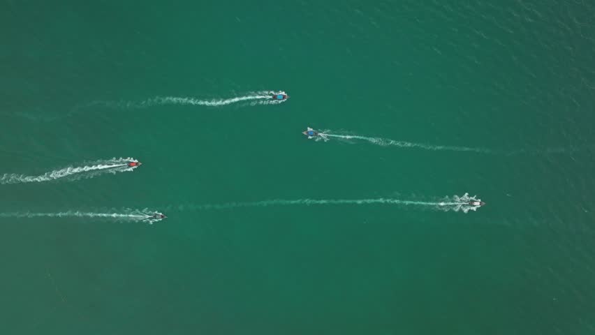 Jet skis racing across the turquoise waters of Thailands coastline