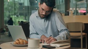 Multitasking stressed overworked Indian businessman multitask work in cafe Arabian business man writing notes checking prices receipt talking mobile phone call Indian male guy with laptop working - Powered by Shutterstock - Get 15% off with code: PIKWIZARD15