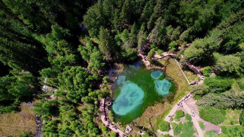 Aerial beautiful landscape Altai, blue geyser lake with clear water surrounded by forest Aktash mountains, Altay Russia drone view.