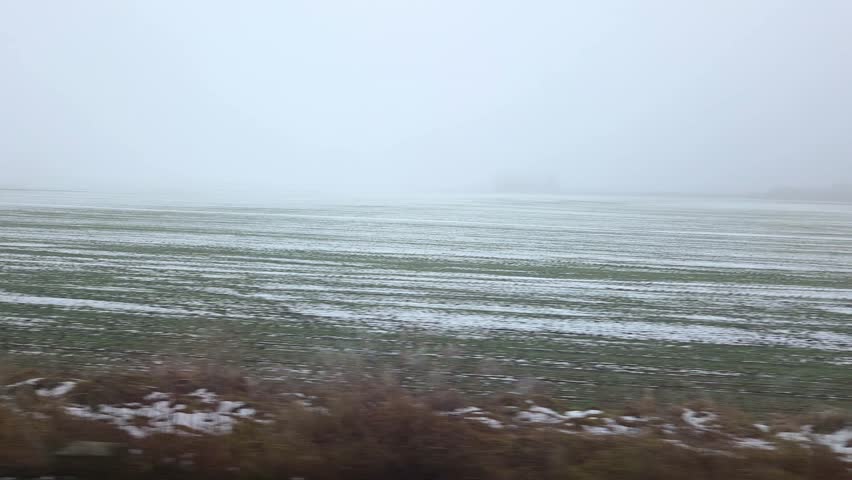 Winter Landscape with Sparse Snow Cover on Agricultural Field