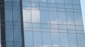 Low angle view of glass facade office building with reflection of clouds on blue sky - Powered by Shutterstock - Get 15% off with code: PIKWIZARD15