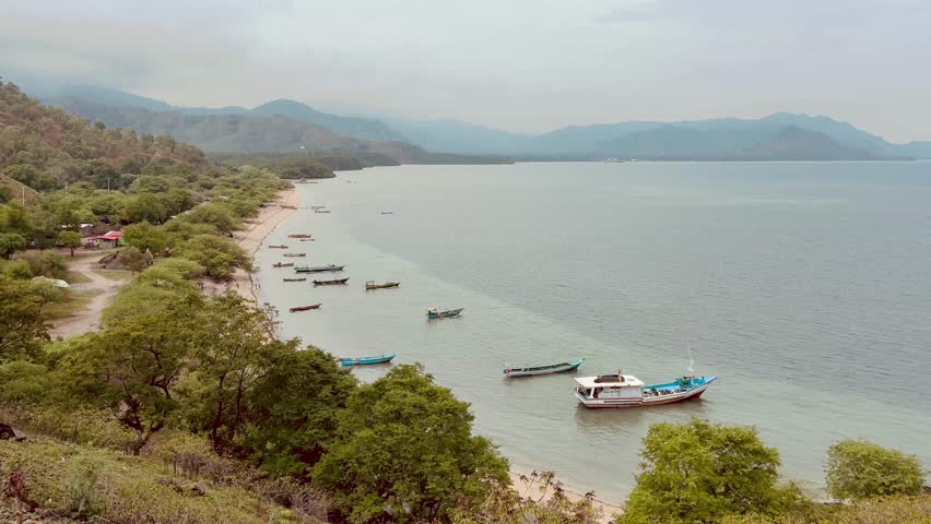 Bay overview with fishing boats and sandy beach in Timor Leste