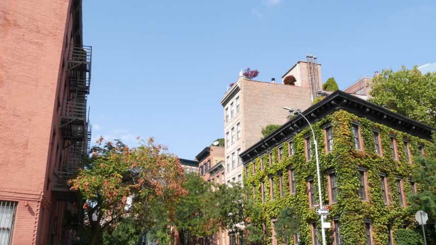 New York City urban residential buildings architecture, Lower Manhattan West village Greenwich street corner, United States of America. Greenwich village, USA. Red brick house. Vine greenery on wall.