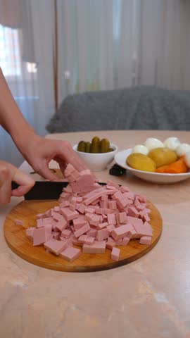 Cooked ham cubes. Sliced ham on the surface for the dish. Sliced ham or boiled sausage on a tray with accompanying ingredients. Ham cubes on the table next to fresh vegetables and spices