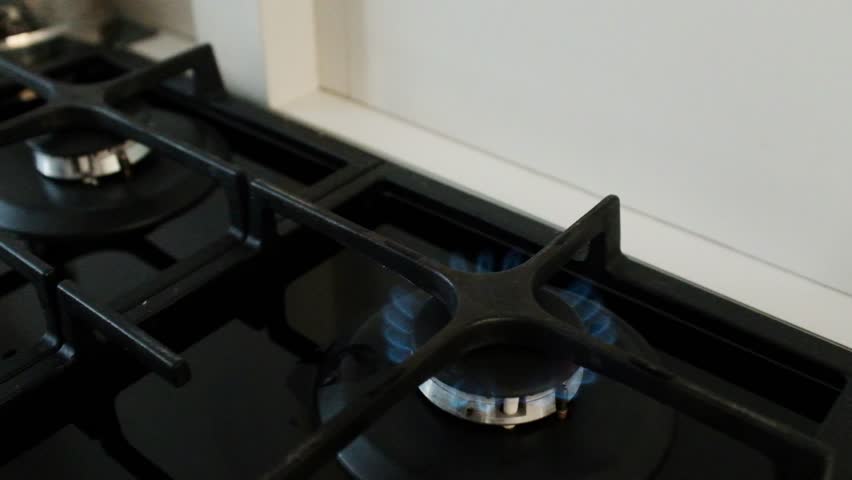 Stainless steel pot filled with water boiling on a gas stove. Home cooking process. Boiling water for making tea or other beverages.