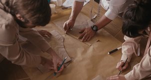 Hands craft clothing patterns with tools, highlighting the art of garment design in a collaborative space - Powered by Shutterstock - Get 15% off with code: PIKWIZARD15