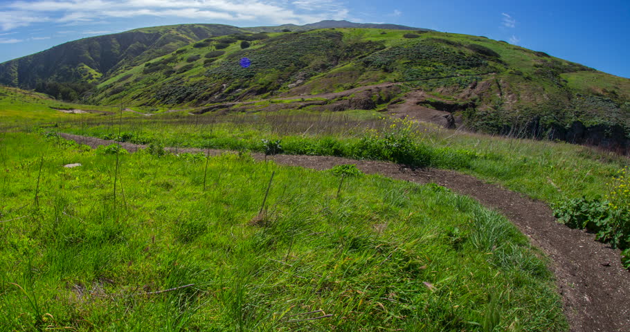 Hikers Walking Along Winding Trail Through Rolling Green Hills on Santa Cruz Island, Channel Islands National Park, California Timelapse