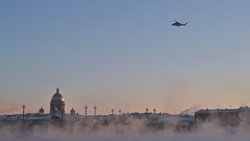 Saint-Petersburg, Russia city center - view from behind the bridge over the  Neva river near Saint-Isaacs cathedral. River vapors hardly in frost , helicopter landing