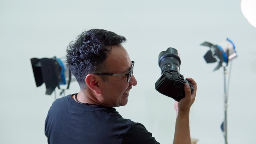 Photographer adjusting the aperture ring during a studio photoshoot