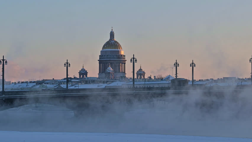 Saint-Petersburg, Russia city center - Isaakievskii Cathedral - russian christian church in winter with snow,  view from behind the bridge. River Neva vapors in frost 