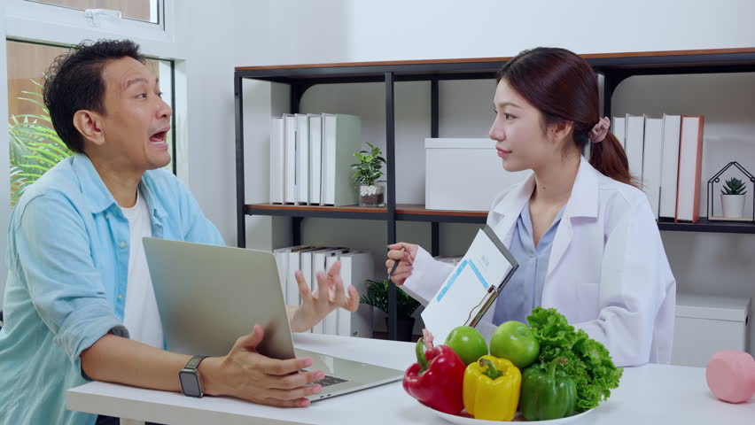 Young asian nutritionist consultation explaining meal plan to patient, doctor guidance meal plan with man, dietitian and patient discussing about nutrient for health, wellness and health advice.