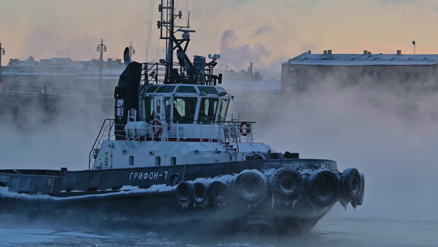 Saint-Petersburg, Russia city center - Neva river vapors in frost . Icebreaker boat floating, breaking ice in the river. Boat name Translation: Griffon-7