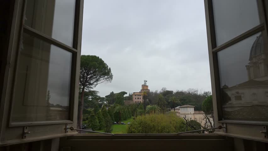 A panoramic window perspective looking over the meticulously manicured lawns fountains and Renaissance architecture of the Vatican Gardens from the museum galleries