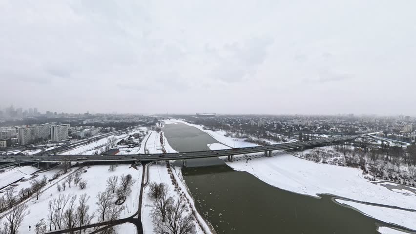 A panoramic aerial shot of snow-covered Warsaw, from the perspective of the Vistula River.