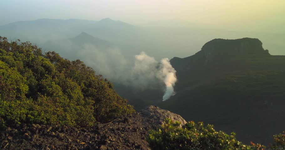 Smoke Plume Rising Over Mountain Ridge at Sunset