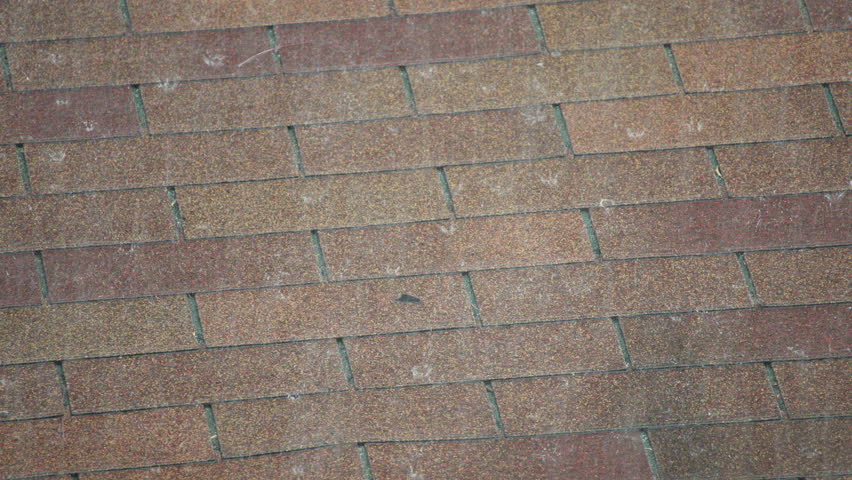Tropical rain falling on roof shingles during heavy rainfall in Thailand. Close up texture of wet roofing surface with water drops. High quality 4k footage