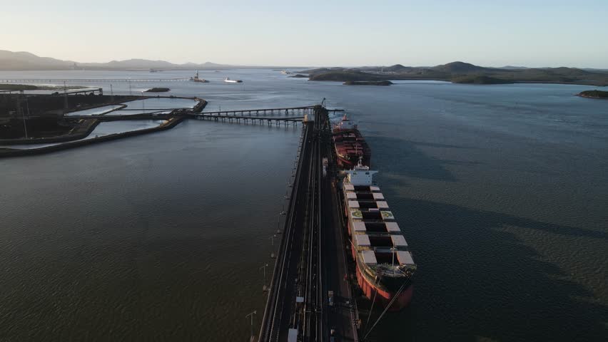 Bulk cargo ships docked at an industrial port loading facility within the Gladstone Harbor Queensland Australia. Drone view