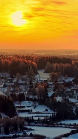Vertical View Of Rural Village Covered With Snow At Sunset. Aerial Shot