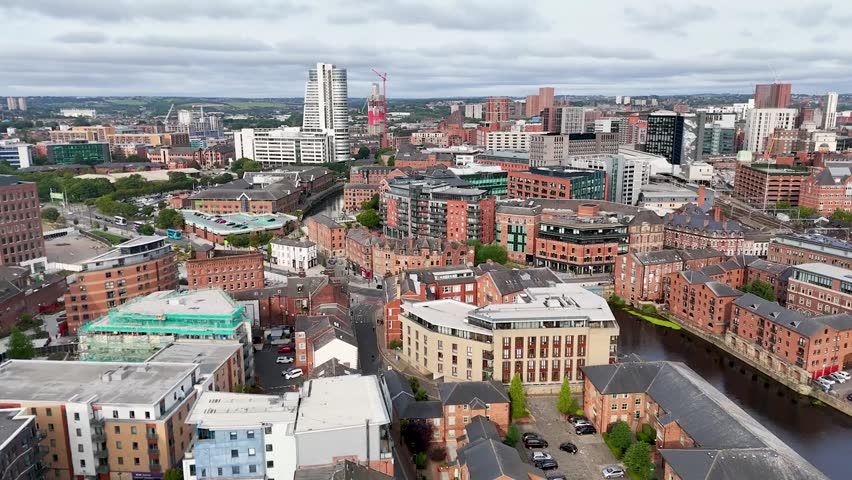 Aerial pan over Leeds cityscape and River Aire, showcasing urban architecture, river views, and the dynamic metropolitan environment of West Yorkshire.