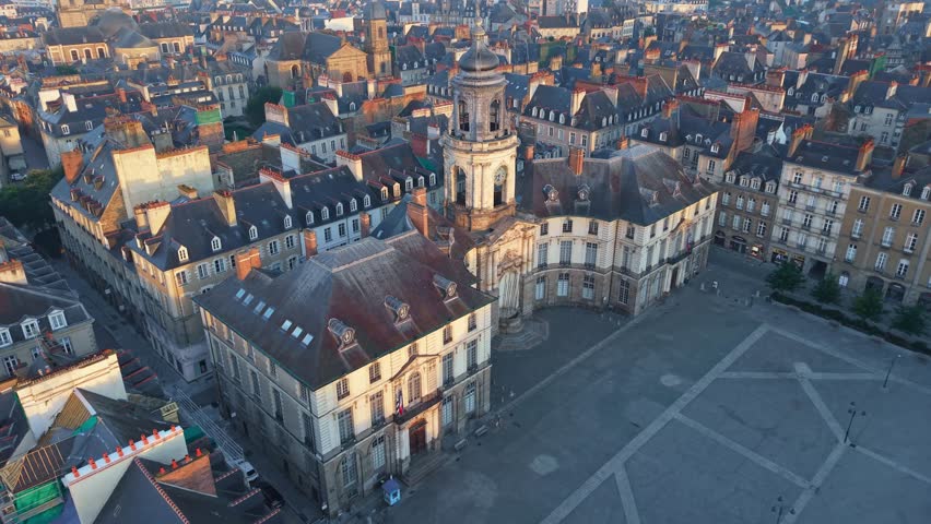Place de la Mairie, the city hall, and the opera house at sunrise in the historic center of Rennes, France. Aerial backward ascending