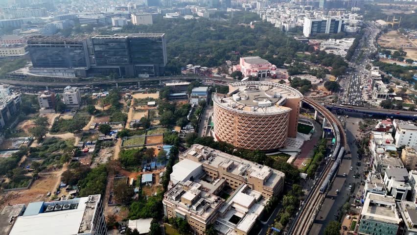 Drone shot over Cyber Towers—circular architecture anchors HITEC City as metro lines and office hubs power Hyderabad’s digital growth.