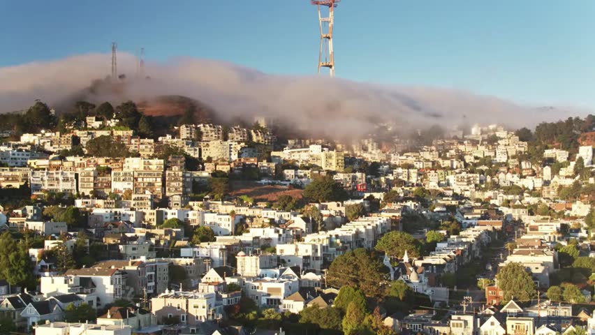 Fog rolling over the city of San Francisco at sunrise, creating a mystical atmosphere with iconic skyline and Golden Gate views in soft morning light.