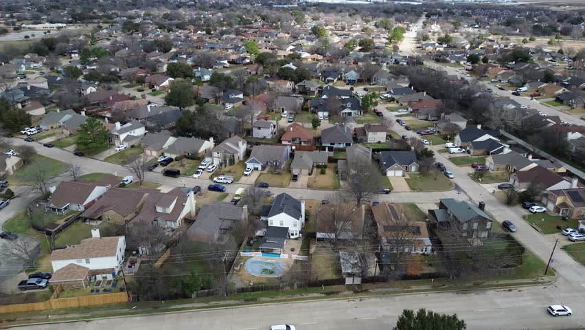 Dense South Arlington suburban blocks near Cravens Park and Fish Creek Linear Park form tight residential grid. Mixed shingles, bare trees, muted lawns, soft winter light in Arlington, Texas. USA