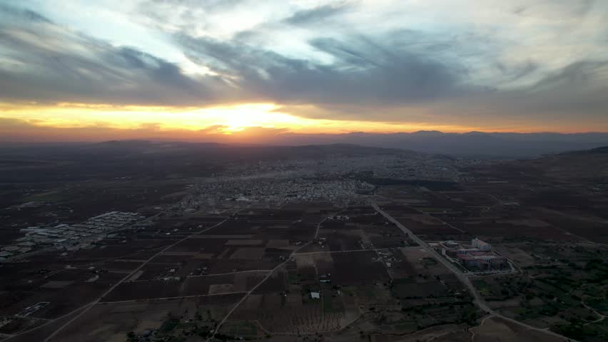 Breathtaking Aerial Sunset Panorama of Kilis Cityscape Surrounded by Agricultural Plains and Distant Mountains in Türkiye