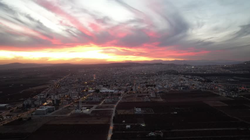 Breathtaking Aerial Sunset Panorama of Kilis Cityscape Surrounded by Agricultural Plains and Distant Mountains in Türkiye