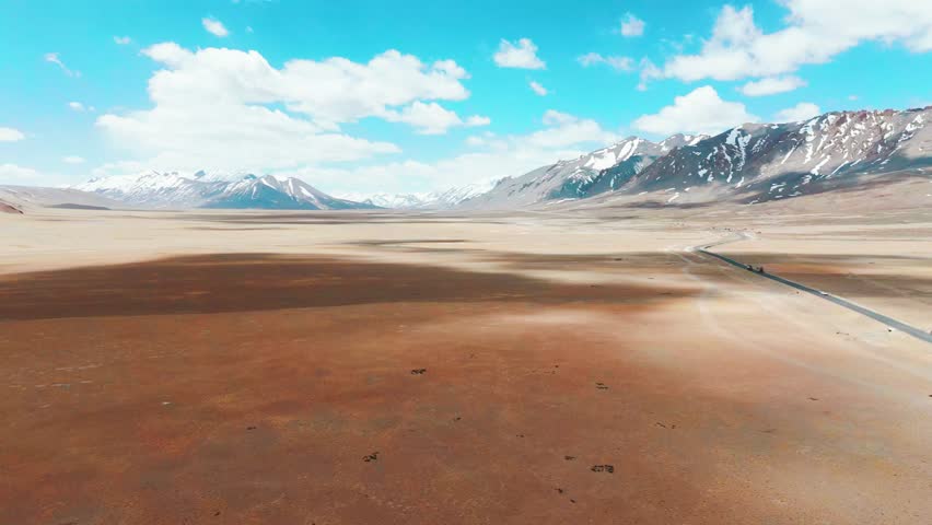 4K Aerial landscape of Ladakh. Road passing through more plain in Ladakh, India. Beautiful road leading towards Himalaya mountains. Travel, adventure and road trip concept.