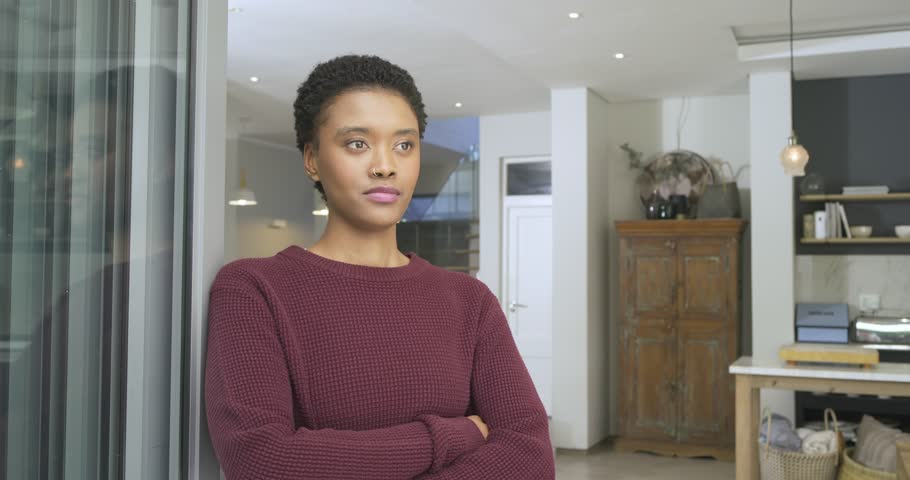 African American woman shifting gaze in living area noticing golden dog emerging and smiling. Contemplation, serenity, elegance, domestic, lifestyle, interior, warm
