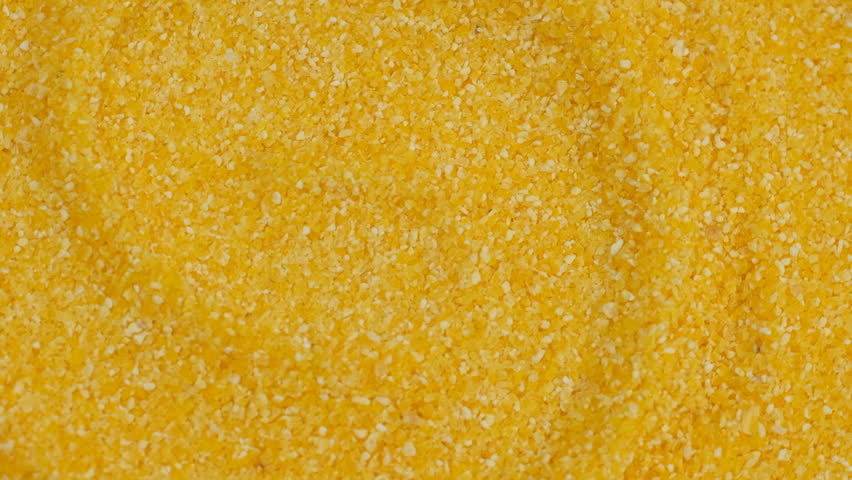 Zoom frame heap of yellow cornmeal, rotate