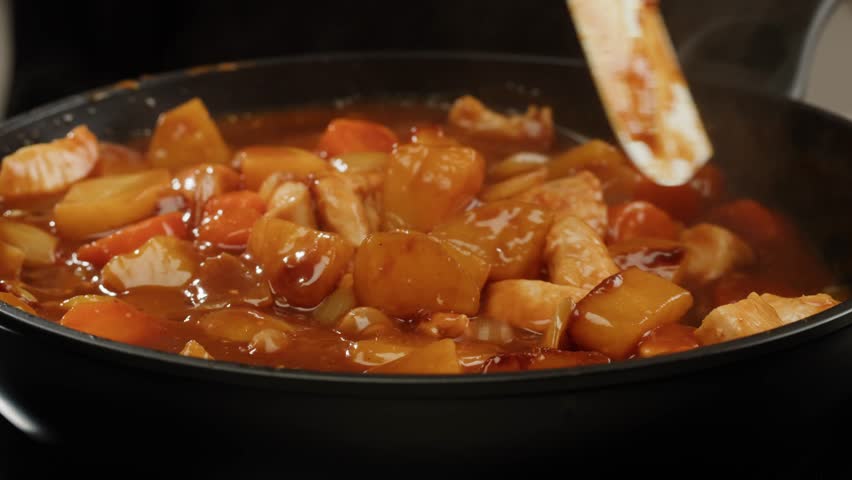 Hungarian goulash soup cooking close-up in pot, chef cook traditional polish or zech soup in restaurant. 