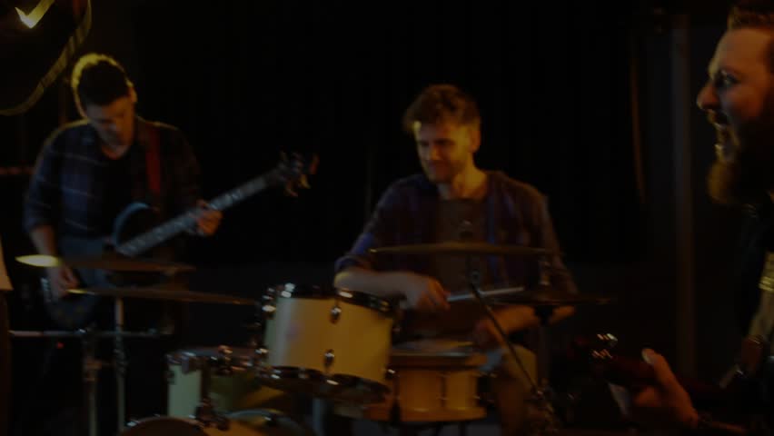 Frontman stepping camera closing in, band playing while finance charts updating to center frontman. Stage, live, performance, ensemble, collaboration, data, visualization