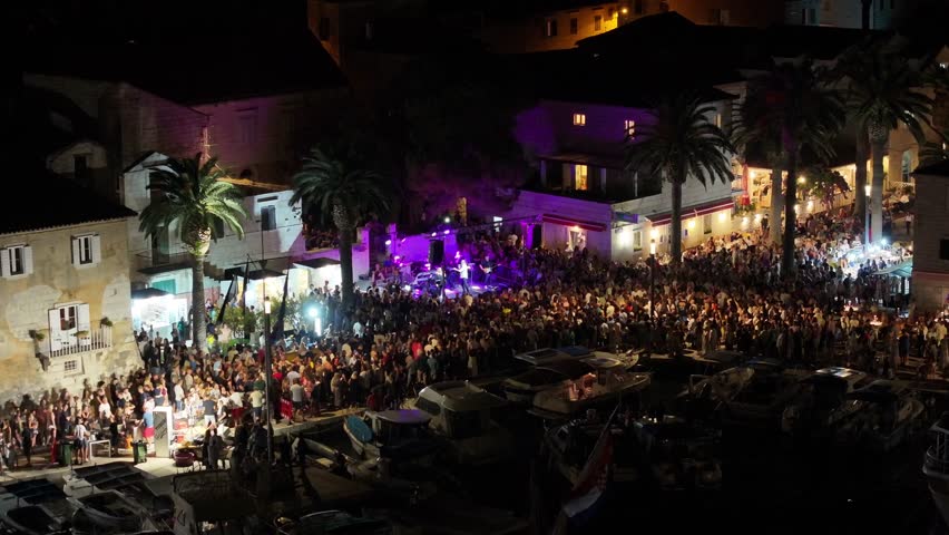 Energetic open air concert on the Riva in Sutivan, Brac island, with festive crowd enjoying summer night in Dalmatia, Croatia.