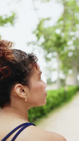 Young woman slowly turning head in park