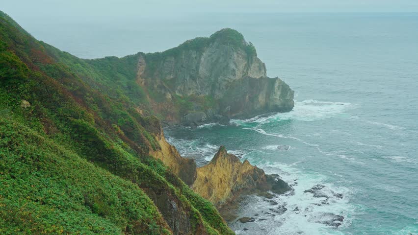 Muroran, Hokkaido, Japan - Oct 04 2024, 4k, panoramic aerial view of the picturesque Pacific ocean coast with sharp cliffs and high mountain slopes, in a storm, it