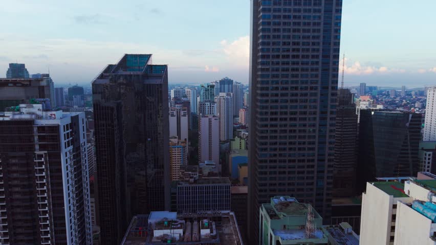 Thick urban smog softens gray towers as drone glides above Makati, Philippines