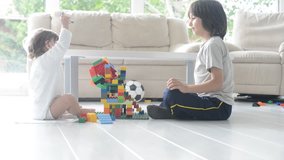 Little cute boy playing at home with toy cubes