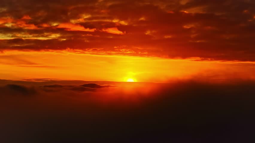 Cinematic sunrise with sun partially obscured by cloud layers