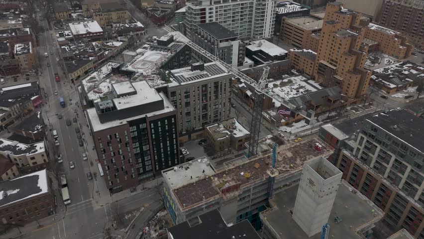 Cinematic 4K drone aerial of the University of Wisconsin–Madison campus covered in fresh snow along the frozen shoreline of Lake Mendota in Madison, Wisconsin. Beautiful cold winter landscape with ice