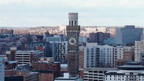 Aerial drone view of downtown Baltimore, with historic clock tower rising above modern residential and office buildings under clear winter sunlight in city skyline. Wide shot. Bromo Seltzer Art tower - Powered by Shutterstock - Get 15% off with code: PIKWIZARD15