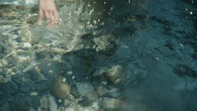 Close up of woman’s hand caressing crystal clear turquoise sea water in Sicily, serene summer Mediterranean detail - Powered by Shutterstock - Get 15% off with code: PIKWIZARD15