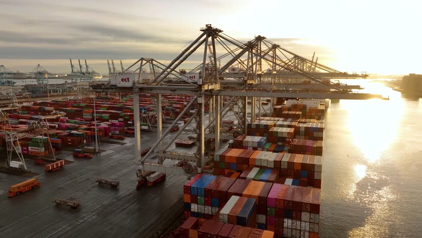 Drone shot of modern industrial port of Rotterdam with containers in sunrise. Sightseeing panorama over sunset. It is an import and export cargo port where is a part of shipping dock