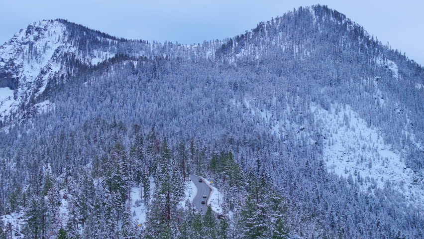 Wide aerial view of Emerald Bay framed by snow covered mountains and dense pine forest along Lake Tahoe shoreline. Clear winter alpine landscape. Emerald Bay, Lake Tahoe, California, USA.