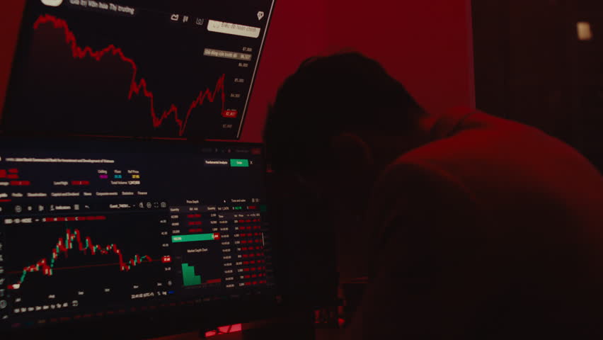 A powerful cinematic shot of a distressed trader in a dark office, illuminated by the red glow of failing market charts as he reacts to a financial crisis