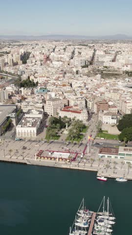 Cartagena cityscape along the Mediterranean coast with yachts marina and urban waterfront. Vertical aerial.