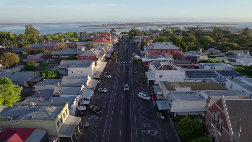 Establishing aerial Queenscliff main street toward the ocean,