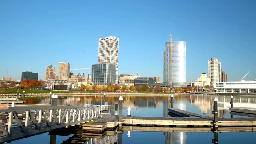 Milwaukee skyline reflects in Lake Michigan on a clear autumn morning, capturing vibrant cityscapes, calm waters, and seasonal beauty.