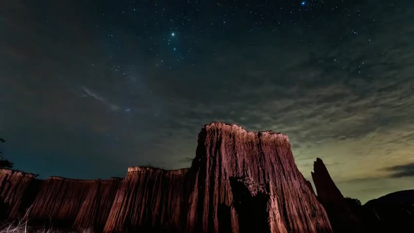 Milky Way illuminates dramatic rock formations at night, creating a stunning celestial and terrestrial landscape under a starry sky.